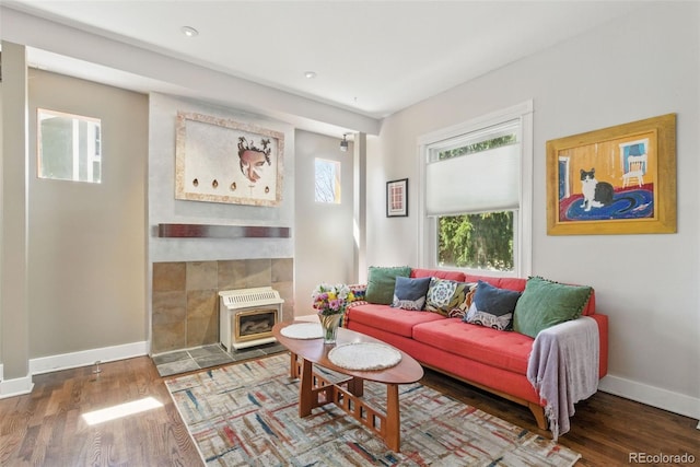 living area featuring wood finished floors, baseboards, and heating unit