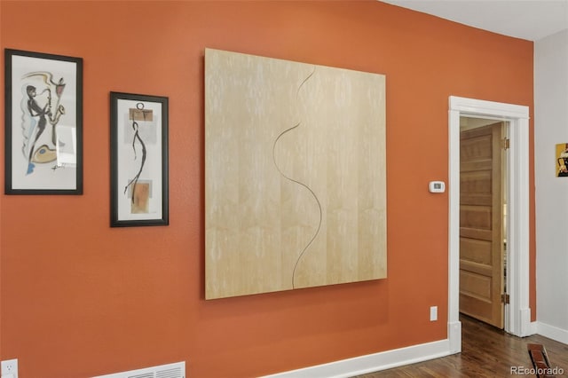 unfurnished room with dark wood-style flooring and baseboards