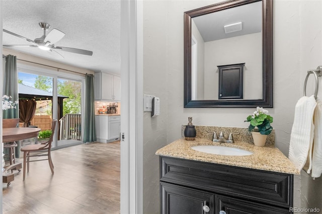 bathroom featuring vanity, a ceiling fan, and wood finished floors