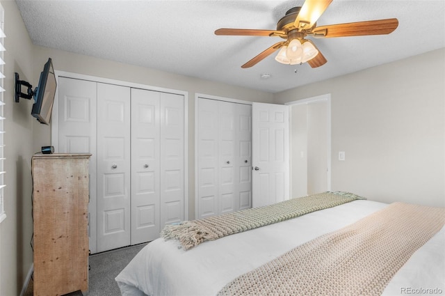 bedroom featuring two closets, carpet floors, and a ceiling fan