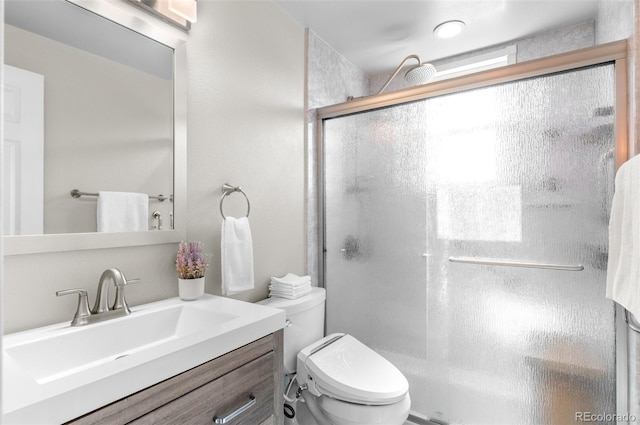 bathroom featuring a stall shower, vanity, and toilet