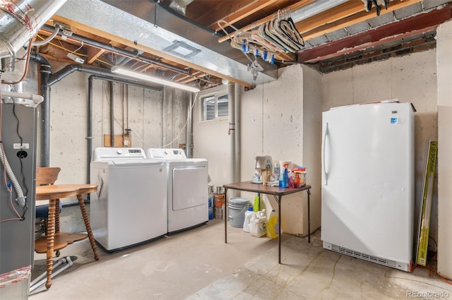unfinished below grade area featuring freestanding refrigerator and separate washer and dryer