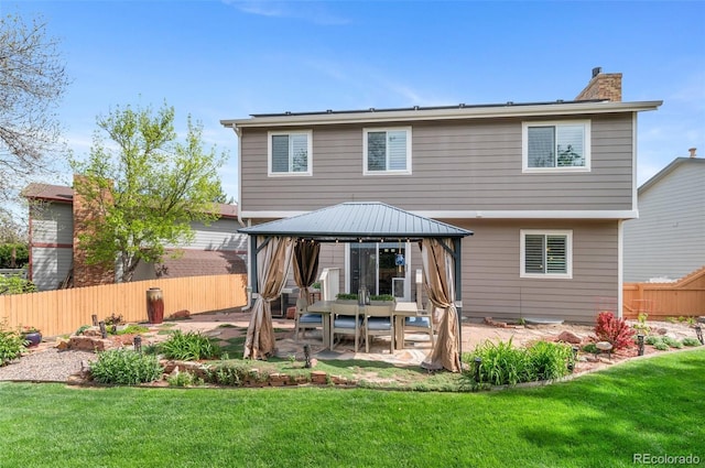 rear view of property featuring a gazebo, a patio area, and a chimney