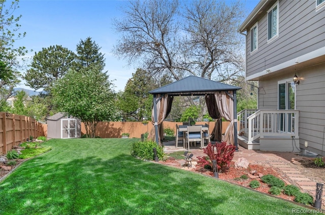 view of yard featuring a gazebo, a storage shed, a patio, and an outbuilding