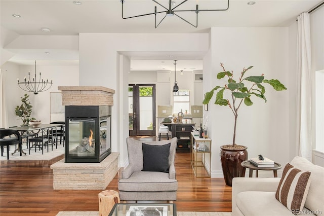 2990 Osceola St, Denver, CO 80212 - living room featuring a chandelier, wood finished floors, a multi sided fireplace, and recessed lighting