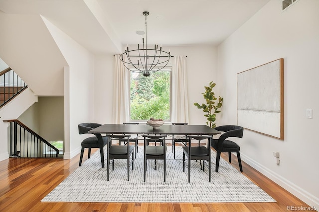 2990 Osceola St, Denver, CO 80212 - dining room featuring wood finished floors, a chandelier, baseboards, and stairs
