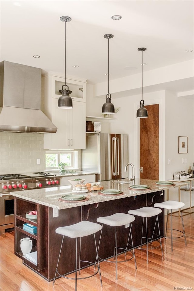 2990 Osceola St, Denver, CO 80212 - kitchen featuring custom range hood, stainless steel appliances, a spacious island, white cabinetry, and light stone countertops