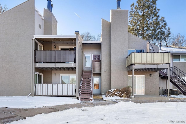 snow covered house featuring cooling unit