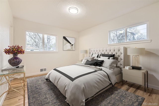 10751 W 66th Ave, Arvada, CO 80004 - bedroom featuring visible vents, wood finished floors, and multiple windows