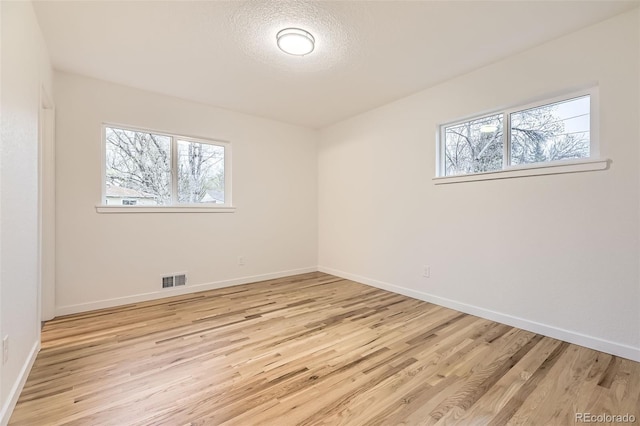10751 W 66th Ave, Arvada, CO 80004 - unfurnished room featuring visible vents, light wood-style flooring, and a wealth of natural light