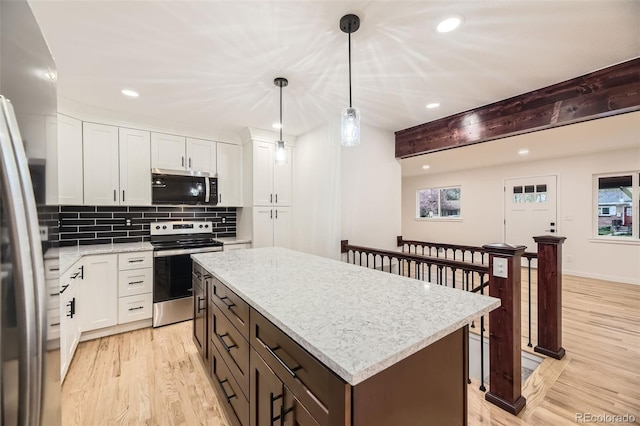 10751 W 66th Ave, Arvada, CO 80004 - kitchen with light wood-style floors, appliances with stainless steel finishes, a kitchen island, and recessed lighting