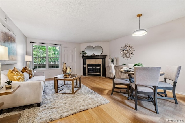 2710 E Otero Pl Unit 6, Centennial, CO 80122 - living area featuring wood finished floors, a tile fireplace, and a textured ceiling