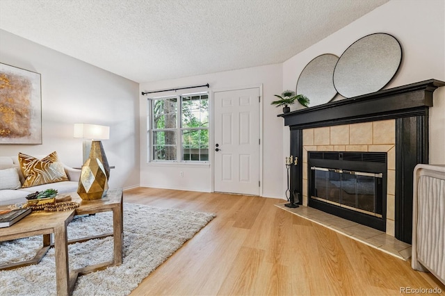2710 E Otero Pl Unit 6, Centennial, CO 80122 - living room featuring wood finished floors, a textured ceiling, and a tiled fireplace