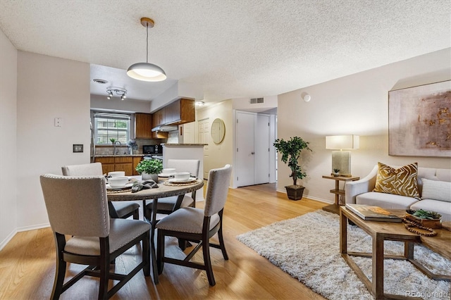 2710 E Otero Pl Unit 6, Centennial, CO 80122 - dining space featuring light wood-style floors and a textured ceiling