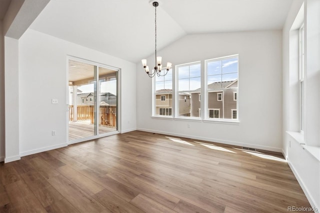 24748 E 40th Ave, Aurora, CO 80019 - unfurnished dining area featuring healthy amount of natural light, a chandelier, wood finished floors, lofted ceiling, and baseboards