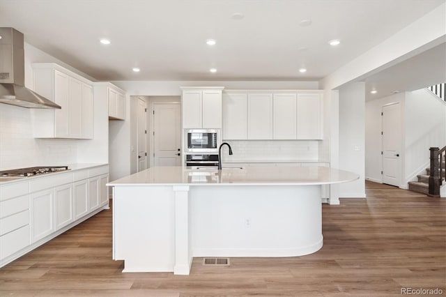 24748 E 40th Ave, Aurora, CO 80019 - kitchen with wall chimney exhaust hood, appliances with stainless steel finishes, tasteful backsplash, light countertops, and recessed lighting