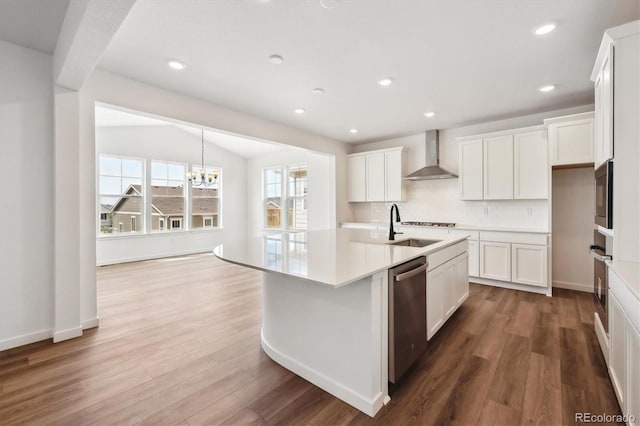 24748 E 40th Ave, Aurora, CO 80019 - kitchen with wall chimney exhaust hood, stainless steel appliances, wood finished floors, a chandelier, and recessed lighting
