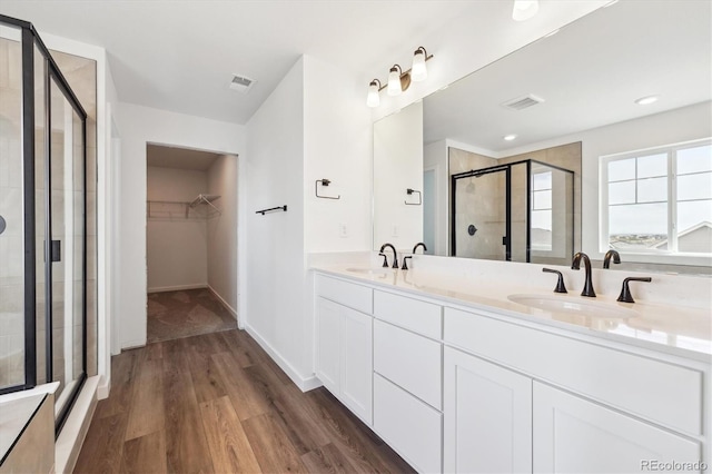 24748 E 40th Ave, Aurora, CO 80019 - full bathroom featuring a shower stall, a spacious closet, wood finished floors, and double vanity