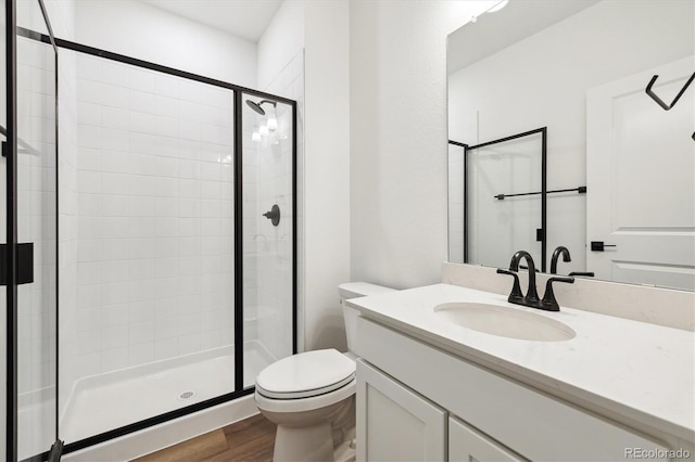 24748 E 40th Ave, Aurora, CO 80019 - bathroom featuring toilet, a shower stall, wood finished floors, and vanity