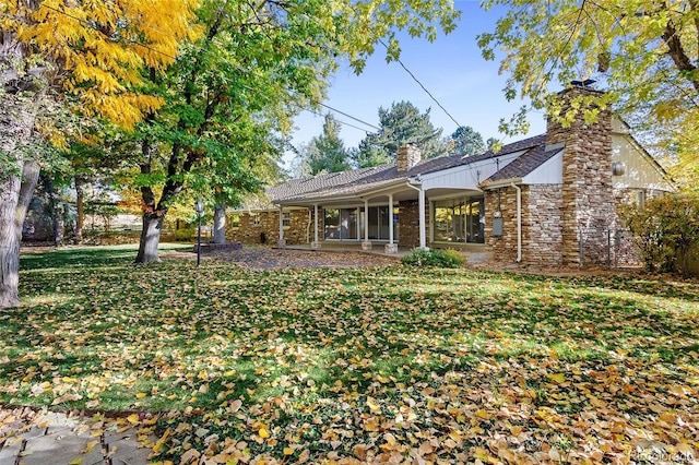 rear view of property featuring a yard