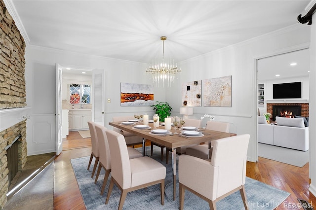 dining area with ornamental molding, a notable chandelier, and light hardwood / wood-style floors