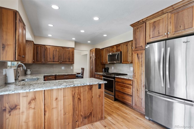 874 Mercury Cir, Lone Tree, CO 80124 - kitchen featuring appliances with stainless steel finishes, tasteful backsplash, recessed lighting, light wood-style flooring, and light stone countertops