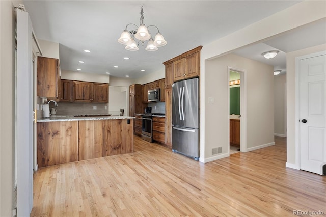 874 Mercury Cir, Lone Tree, CO 80124 - kitchen with stainless steel appliances, decorative backsplash, light wood-type flooring, a peninsula, and a chandelier