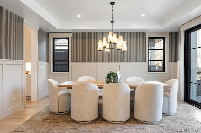 dining space featuring a healthy amount of sunlight, an inviting chandelier, and a tray ceiling