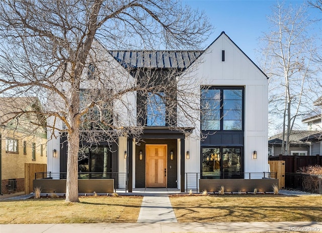 modern farmhouse with board and batten siding, brick siding, and fence