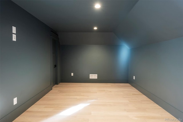 spare room with recessed lighting, visible vents, vaulted ceiling, and light wood-style flooring