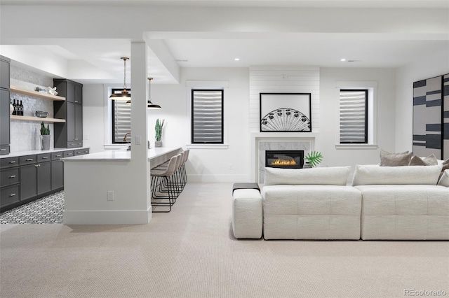 living room with a premium fireplace, baseboards, and recessed lighting