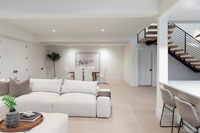 living room featuring recessed lighting, light colored carpet, stairway, and baseboards