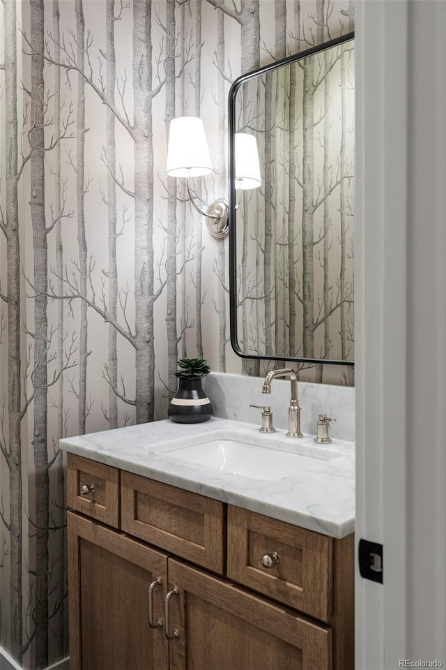 bathroom featuring vanity and wallpapered walls