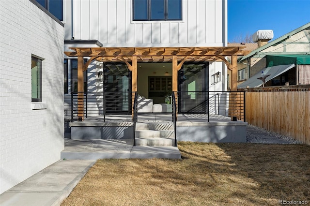 entrance to property with brick siding, board and batten siding, fence, and a pergola