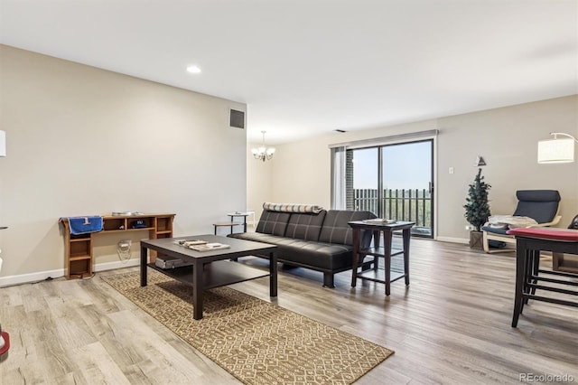 living room with wood finished floors, a chandelier, baseboards, and recessed lighting