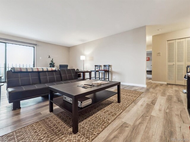 living area with light wood-style flooring and baseboards