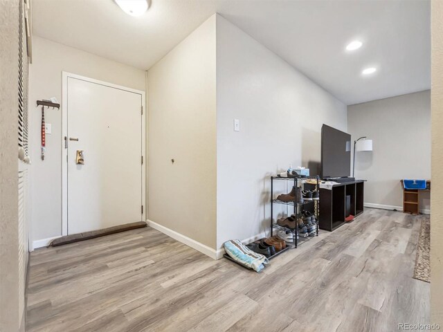 hall featuring wood finished floors, baseboards, and recessed lighting