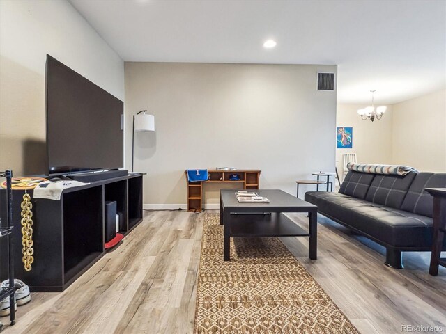 living room featuring light wood-style flooring, a chandelier, and recessed lighting