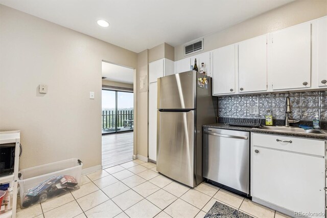 kitchen featuring stainless steel appliances, a sink, white cabinets, tasteful backsplash, and recessed lighting