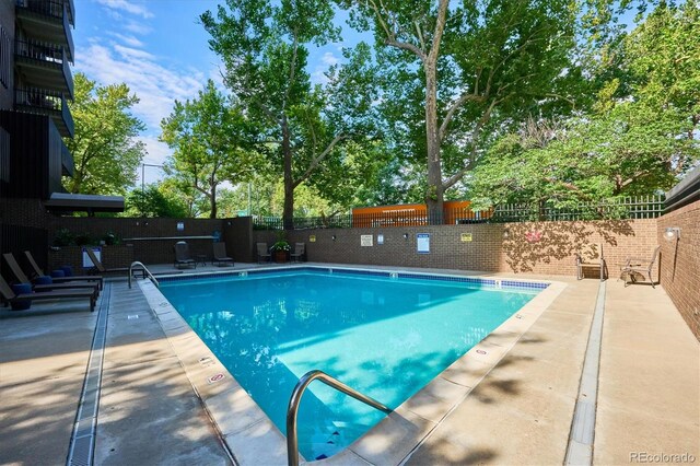 community pool featuring a fenced backyard and a patio area