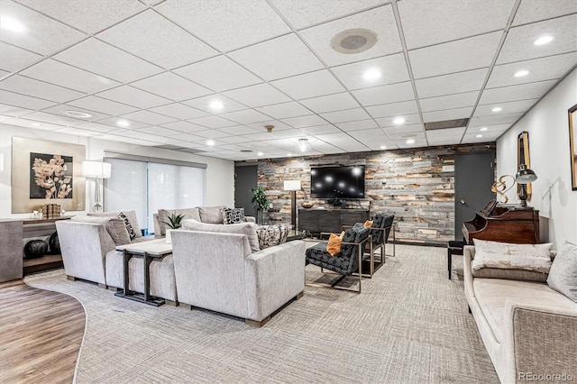 living area featuring wood finished floors, a paneled ceiling, recessed lighting, and a fireplace