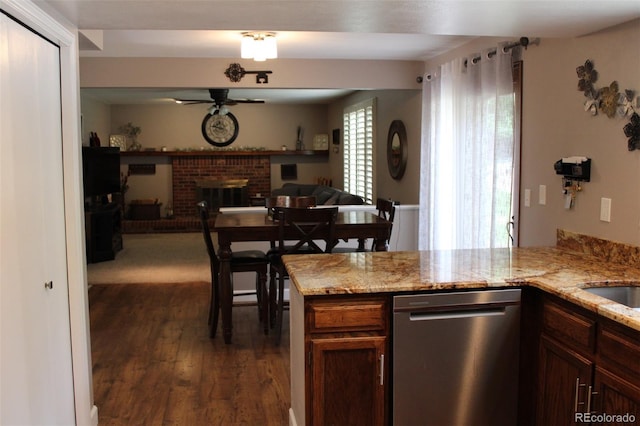 7394 S Field Ct, Littleton, CO 80128 - kitchen with stainless steel dishwasher, ceiling fan, a fireplace, dark wood finished floors, and light stone countertops