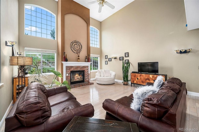 5774 S Genoa Ct, Aurora, CO 80015 - living room with a towering ceiling, ceiling fan, wood finished floors, and a fireplace