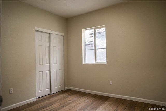 1511 E Routt St Ave, Pueblo, CO 81004 - unfurnished bedroom featuring a closet, wood finished floors, and baseboards