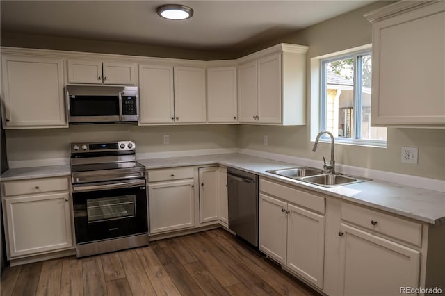 kitchen with white cabinetry, sink, appliances with stainless steel finishes, and dark hardwood / wood-style flooring