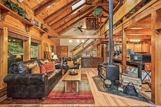 1673 Sinton Rd, Evergreen, CO 80439 - living area with hardwood / wood-style flooring, a wood stove, high vaulted ceiling, wood ceiling with exposed beams, and ceiling fan