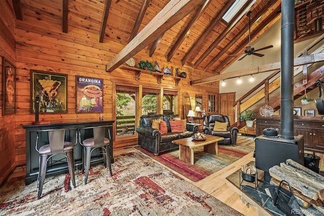 1673 Sinton Rd, Evergreen, CO 80439 - living room featuring a wood stove, wood ceiling with exposed beams, wood walls, wood finished floors, and high vaulted ceiling