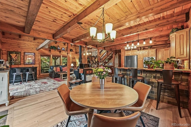 1673 Sinton Rd, Evergreen, CO 80439 - dining space featuring wooden ceiling with exposed beams, a chandelier, light wood-style floors, and wood walls