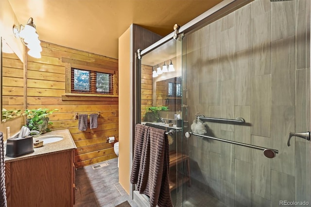1673 Sinton Rd, Evergreen, CO 80439 - bathroom with wood walls, a shower stall, vanity, and toilet