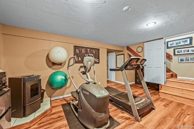 1673 Sinton Rd, Evergreen, CO 80439 - exercise area featuring wood finished floors, baseboards, and a wood stove